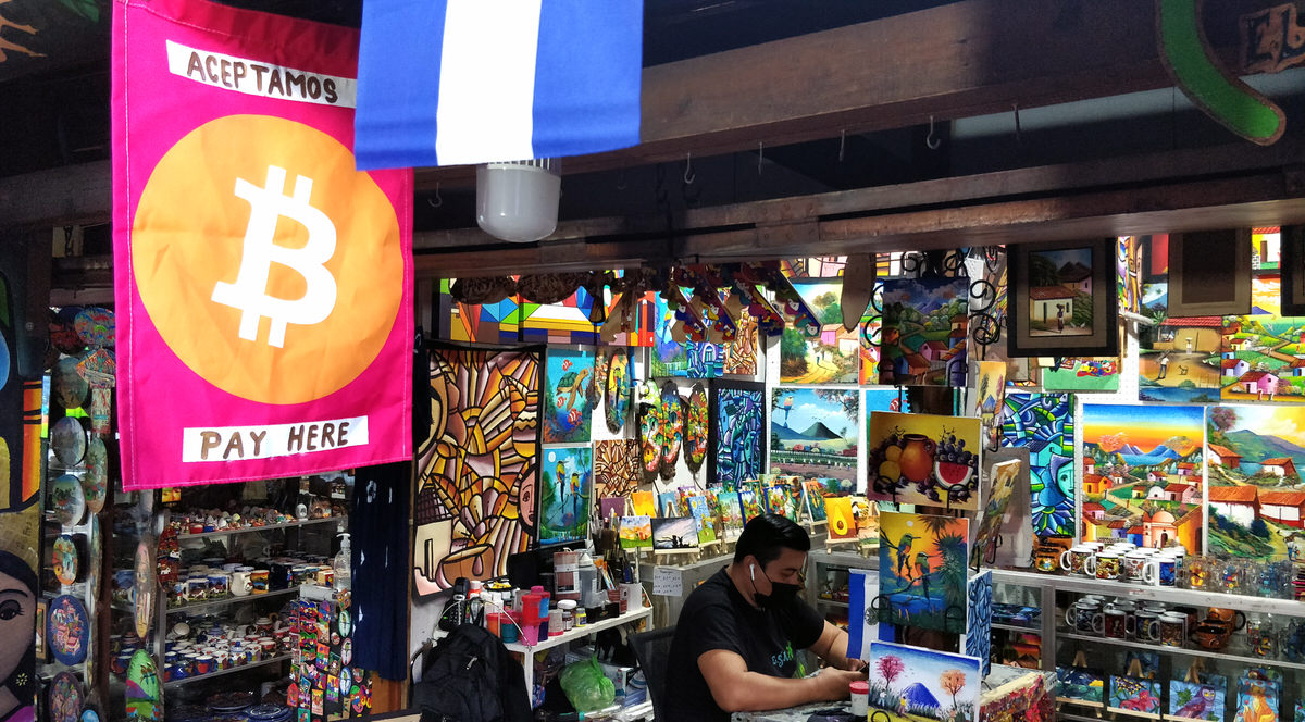 Ein farbenfroher Markt mit handwerklichen Erzeugnissen und Souvenirs aus El Salvador. An einem Stand ein große Fahne mit einem Bitcoin-Symbol.